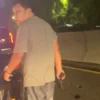 Video viral seorang pria menenteng pistol turun dari mobil polisi dan menganiaya sopir taksi online
